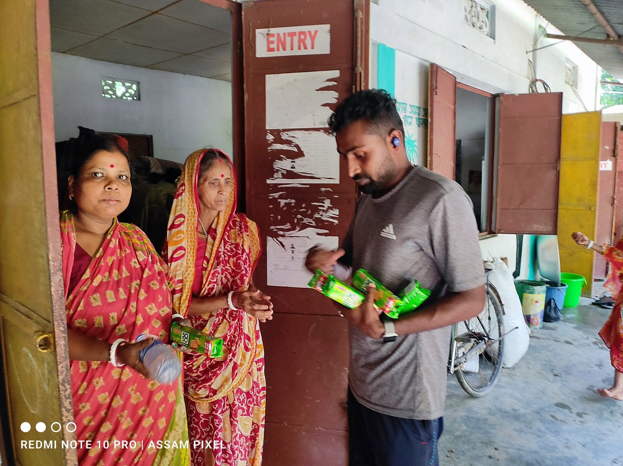 Volunteer handing essential food packets to village residents.